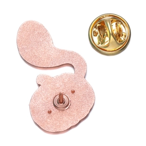 Détail de l'envers du badge citrouille en or rose avec son fermoir papillon doré