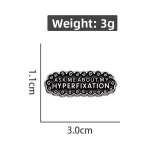 Detail showing 'ASK ME ABOUT MY HYPERFIXATION' enamel pin dimensions 3.0cm by 1.1cm