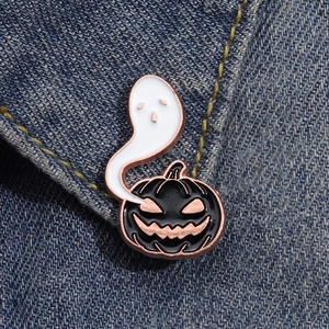 Épingle en émail d'Halloween avec citrouille et fantôme sur fond de jean bleu