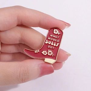 Red enamel cowboy boot brooch badge with What Would Dolly Do text and gold trim