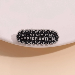 Black enamel rectangular badge pin with Ask Me About My Hyperfixation slogan