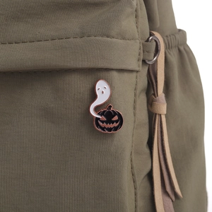 Gros plan d'un pin's d'Halloween avec fantôme et citrouille sur un sac en toile