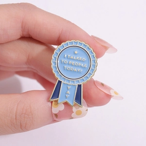 Funny enamel pin showing I TALKED TO PEOPLE TODAY award ribbon held by hand