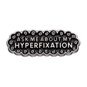 Minimalist black enamel oval brooch pin with Ask Me About My Hyperfixation slogan