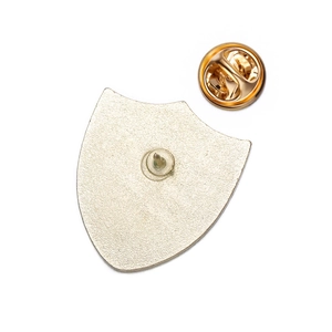 Detailed back view of shield-shaped metal badge with matte finish and golden butterfly clutch