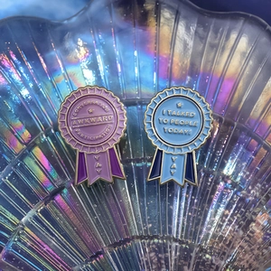 Detail of creative enamel medal brooches with funny text on a pearlescent shell tray
