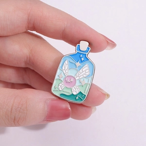 Blauer Emaille-Pin in Flaschenform mit rosa geflügeltem Wesen und Sternenhimmel