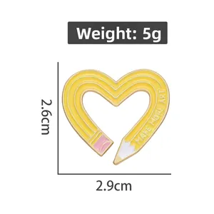 Detail of yellow heart pencil enamel pin measuring 2.6cm x 2.9cm and weighing 5g