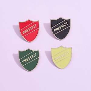 Shield enamel pins with PREFECT lettering in red, black, green and yellow colors