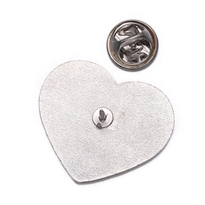 Detail of silver heart-shaped metal brooch pin base with butterfly clutch back