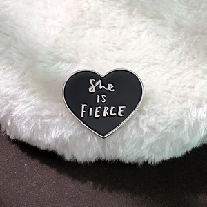 Black heart enamel pin with She IS FIERCE quote and polished silver metal edges