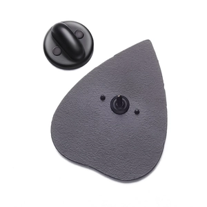 Detail of enamel pin back featuring grey alloy texture and black rubber clutch closure