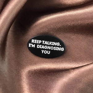 Détail du pin's émaillé Keep Talking I'm Diagnosing You sur fond de soie marron