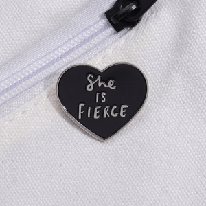 Black heart enamel brooch with 'She IS FIERCE' silver text on white canvas bag