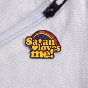 Regenbogen Emaille Pin mit Satan Loves Me Schriftzug auf weißem Canvas-Untergrund