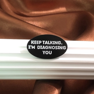 Broche géométrique en métal avec texte Keep Talking I'm Diagnosing You sur émail noir