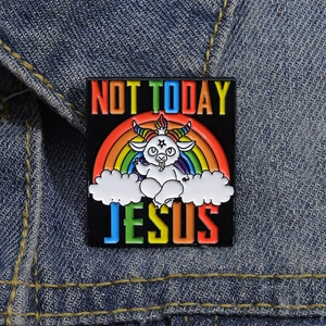 Macro detail of 'NOT TODAY JESUS' rainbow text on black enamel pin against blue denim