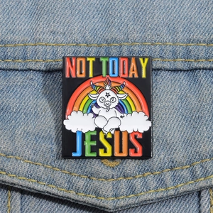 Close-up of rainbow enamel pin with cartoon goat and Not Today Jesus text on denim
