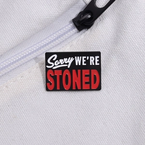 Kreative Emaille-Anstecknadel mit Sorry WE'RE STONED Slogan auf weißem Segeltuchhintergrund