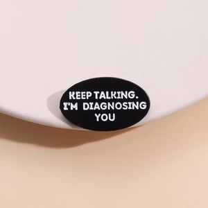Black oval enamel brooch with Keep Talking I'm Diagnosing You text for psychologists