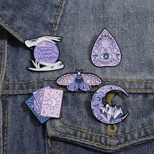 Lot de 5 broches émaillées tarot et cristal violet sur une poche de veste en jean
