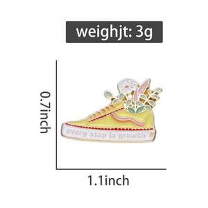 Detailed view of yellow sneaker enamel pin with floral motifs and growth quote engraving