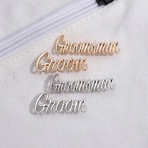 Minimalist gold and silver metal brooches for Groom and Groomsman on white fabric
