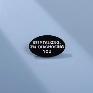 Keep Talking I'm Diagnosing You enamel pin brooch on blue background with soft shadows