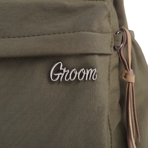 Close-up of olive green woven bag featuring silver Groom logo and side drawstring detail