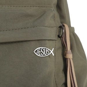 Detailed macro view of olive green fabric with Jesus fish metal emblem and leather trim