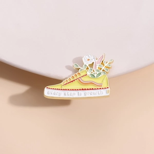Creative yellow skateboard shoe enamel brooch with Every Step Is Growth quote
