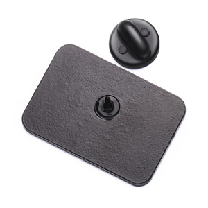 Matte black geometric metal badge back view with matching soft rubber pin clutch