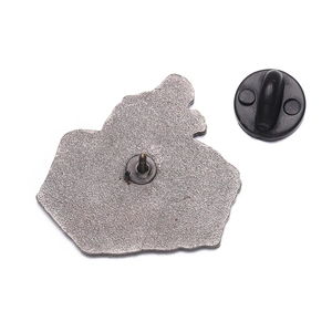 Detail of the metal brooch back with matte texture, sharp pin, and black rubber clutch