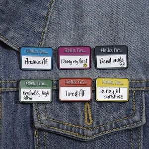 Set of six colorful Hello I'm enamel pins with funny slogans on blue denim jacket
