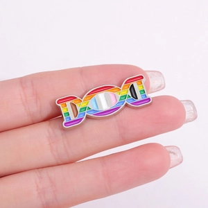 Detailed view of rainbow enamel DNA double helix brooch held against a pink background