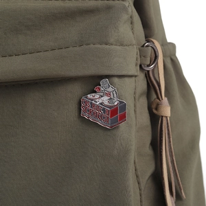 Detail of knight DJ enamel pin with 'Tis But A Scratch text on green fabric bag