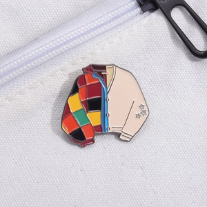 Detail of colorful patchwork jacket enamel pin showing intricate stitching and star patterns