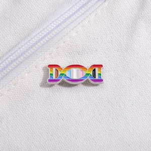 Detailed close-up of rainbow DNA helix enamel pin on white canvas texture fabric
