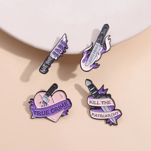 Set di spille gotiche a forma di pugnale viola con slogan su sfondo beige