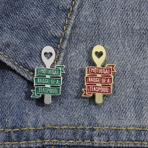 Lot de deux pins cuillère en émail avec citation gravée sur fond en denim