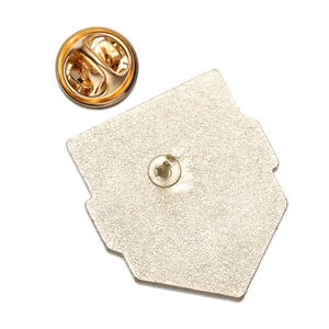Detail of the golden metal pin badge back with matte texture and butterfly clutch fastener