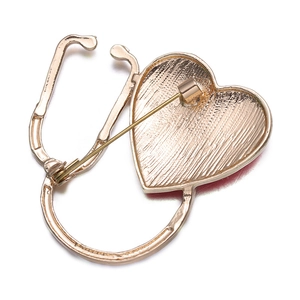 Detailed back view of gold stethoscope brooch showing pin clasp and brushed metal texture