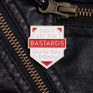 Macro detail of enamel shield badge with text on black leather jacket and brass zipper