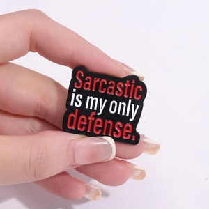 Black enamel pin with Sarcastic Is My Only Defense text in red and white lettering