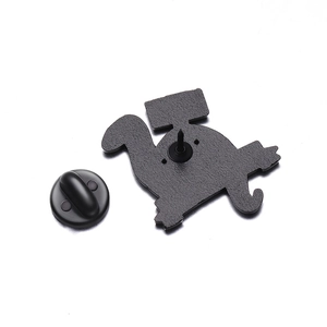 Detail view of cartoon badge back showing the metal pin and black rubber clutch backing
