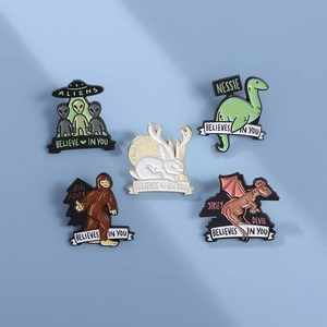 Five-piece cryptid enamel pin set with BELIEVES IN YOU slogan on blue background