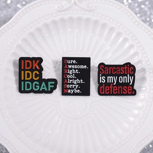 Three-piece black enamel pin set featuring sarcastic humor quotes on white plate