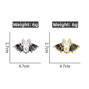 Detail showing gold and silver bat enamel pins with moon motifs and glitter wings