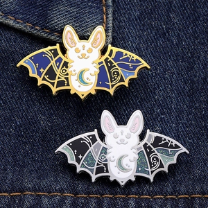 Dark punk bat rabbit enamel pins set with celestial motifs on blue denim background