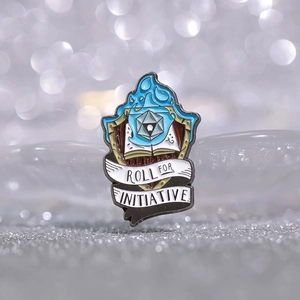 Pin's émaillé flamme bleue avec dé D20 et livre, slogan Roll for Initiative sur paillettes